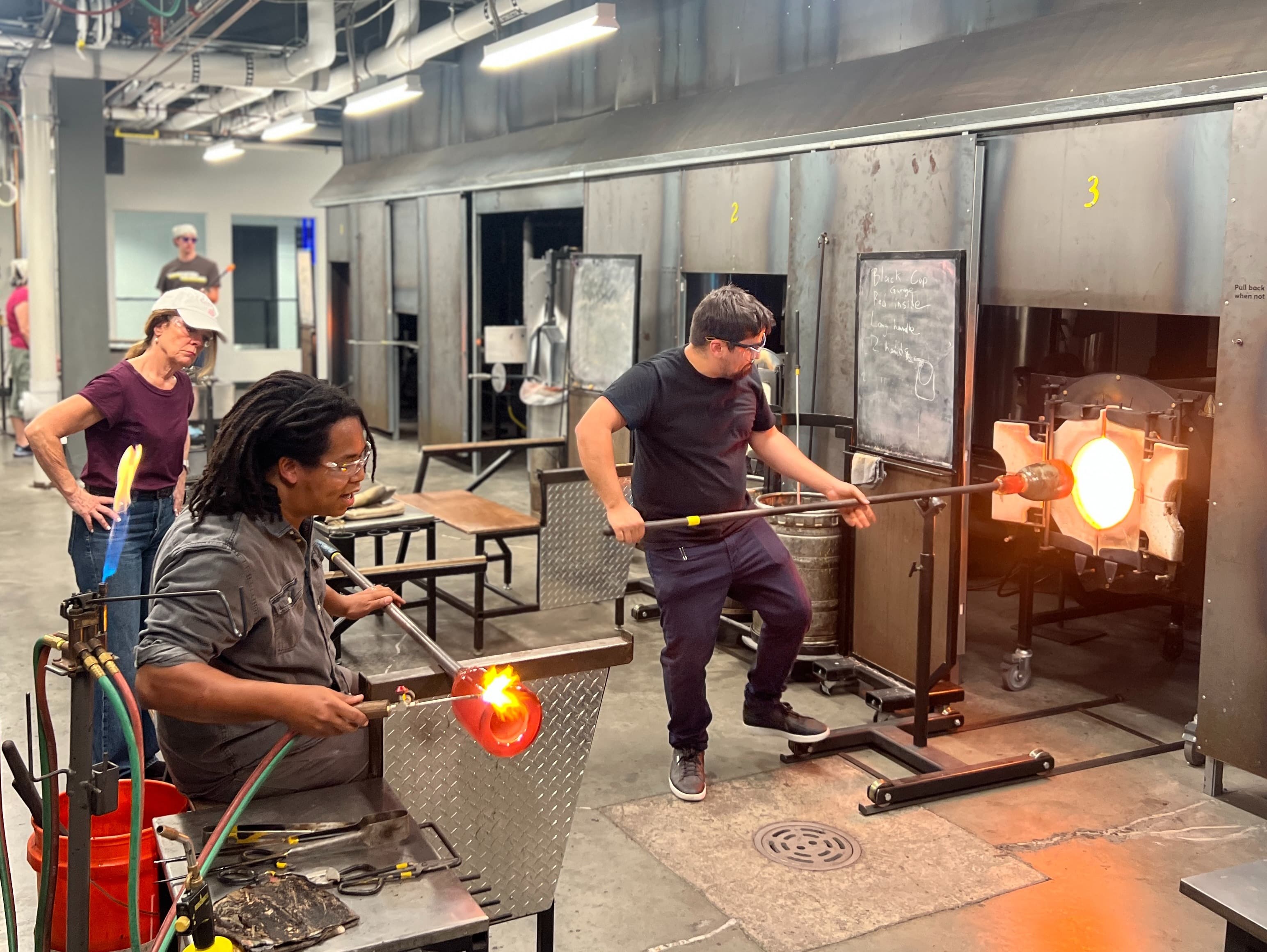 Artists Margot Dermody, Chris Ross, and Eric Hernandez preparing work at the Pittsburgh Glass Center.