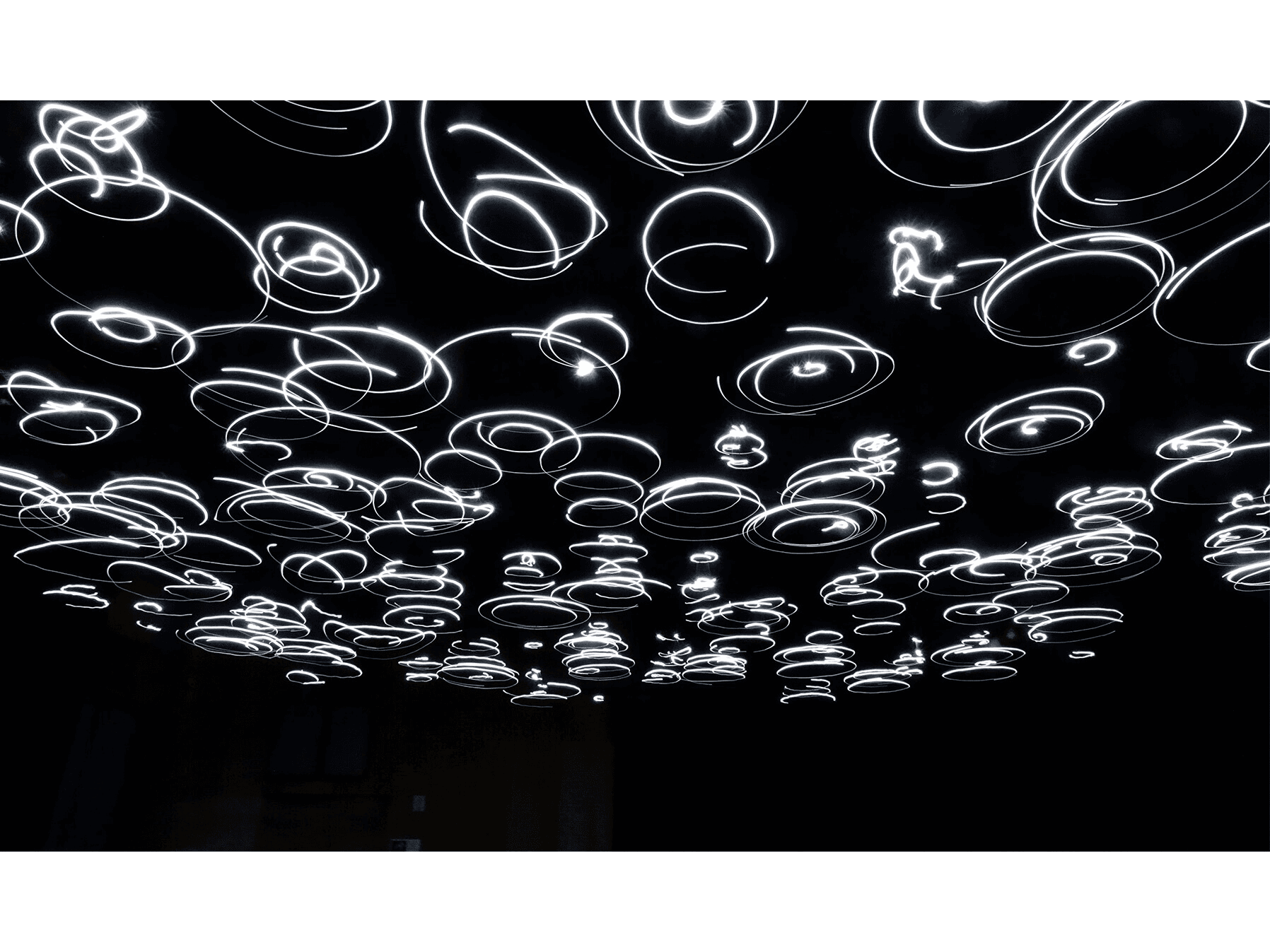 Sally Weber and Craig Newswanger, Entangled Attraction, 2024, LED spinner lights on ceiling frame and soundscape. Collection of The Butler Institute of American Art.